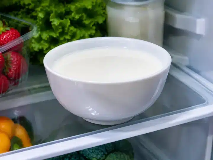 Bol de lait blanc posé sur une clayette refrigeree