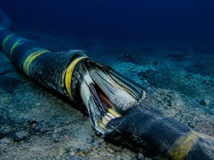 Câble sous-marin endommagé gisant sur fond océanique sombre