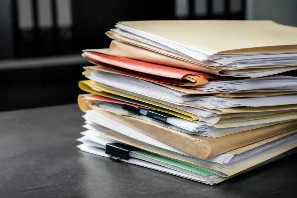 Documents administratifs allemands empilés sur bureau gris