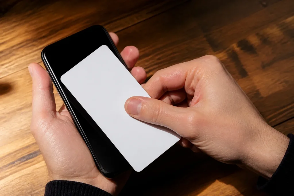 Main posant feuille papier blanc contre smartphone