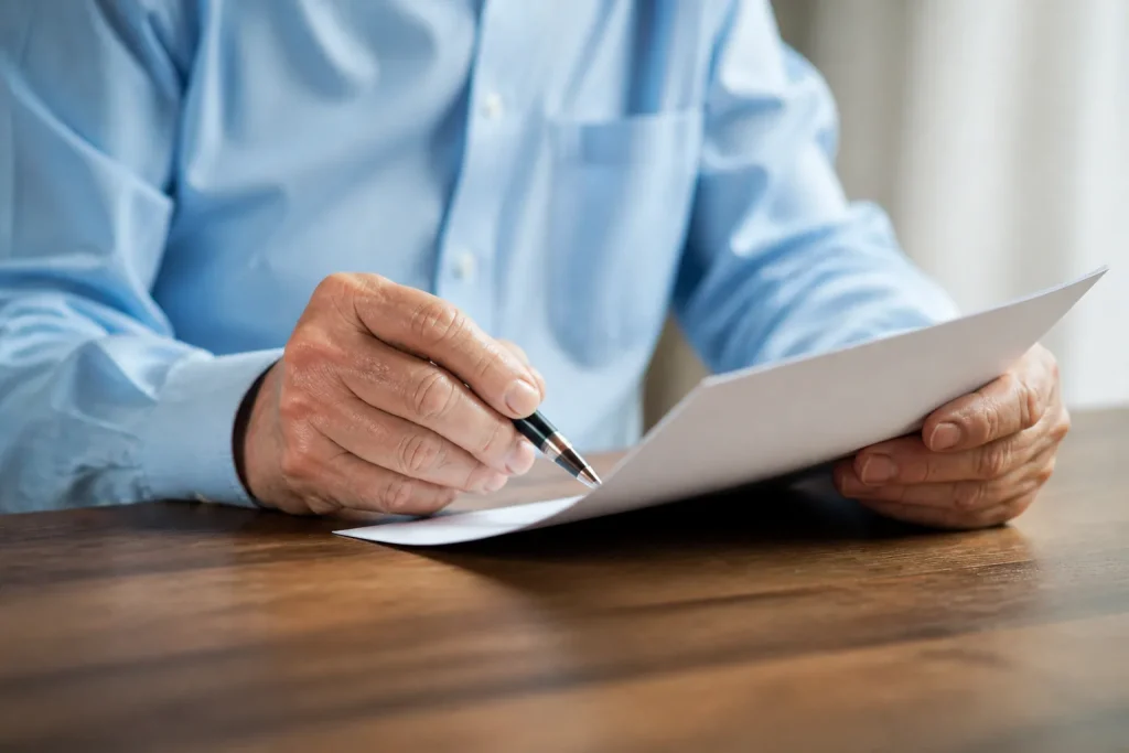 Mains examinant document pension avec stylo