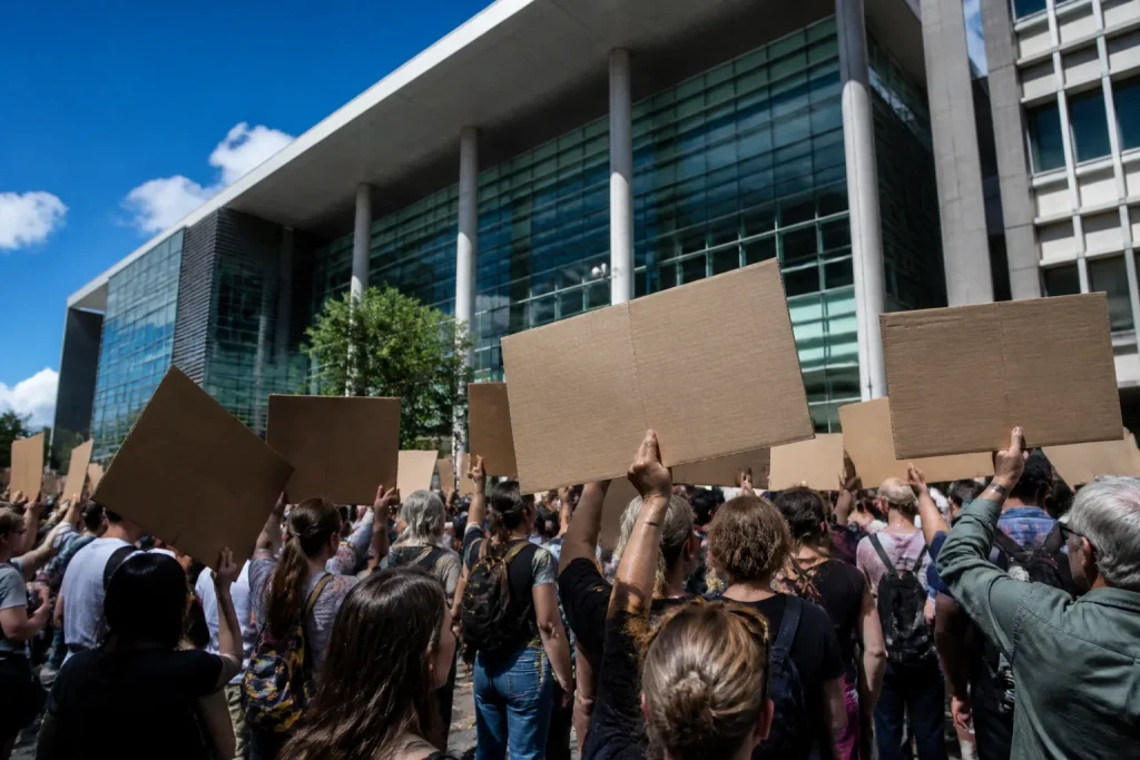 Manifestants brandissant pancartes devant tribunal administratif moderne