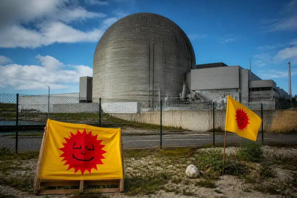 Reactor containment with warning signs and protest banners visible