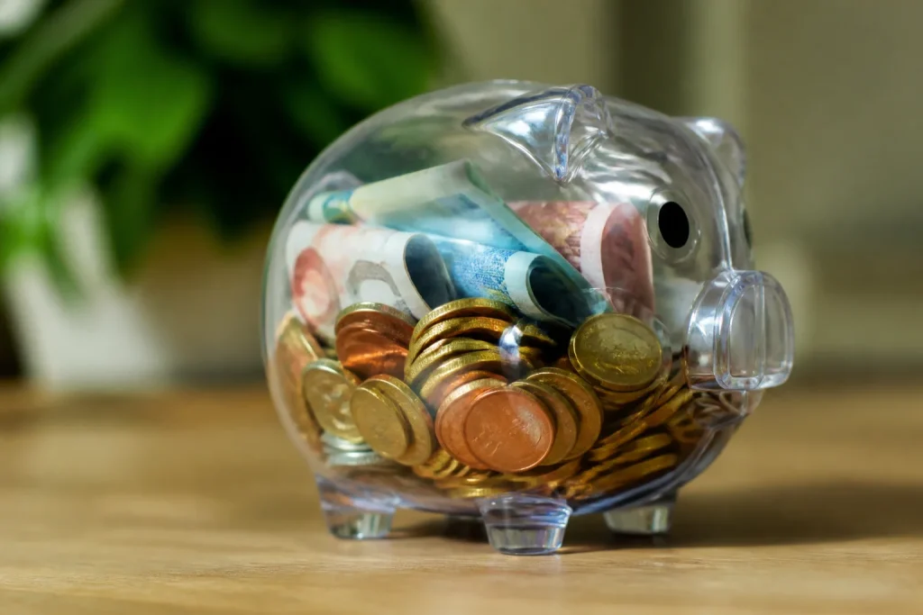 Tirelire transparente remplie de pieces et billets
